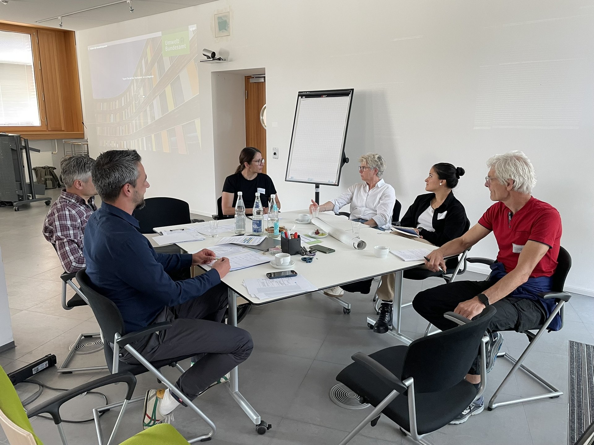6 Personen sitzen um einen Tische bei einem Workshop in Dessau.