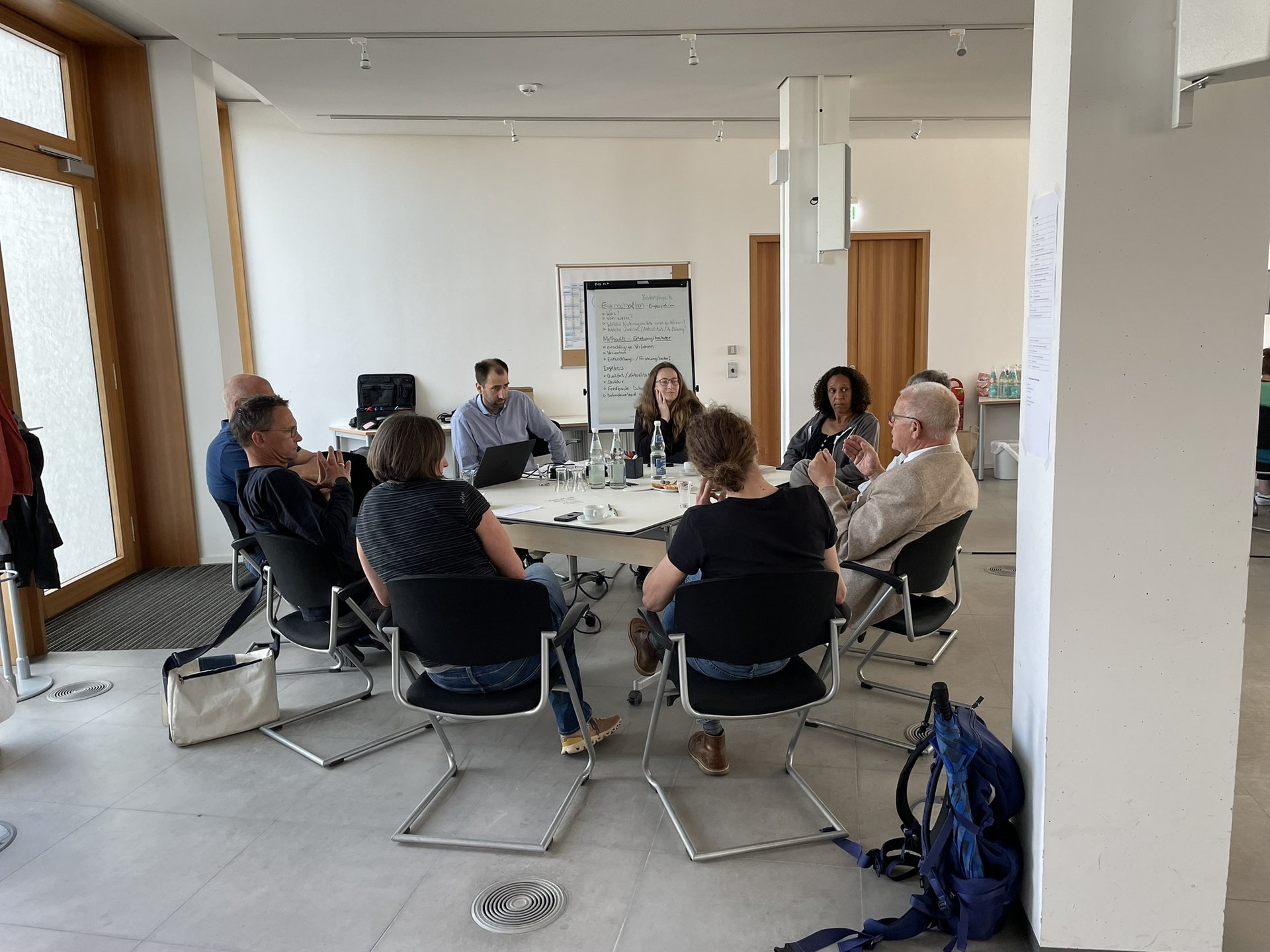 8 Personen sitzen um einen Tisch bei einem Workshop in Dessau.
